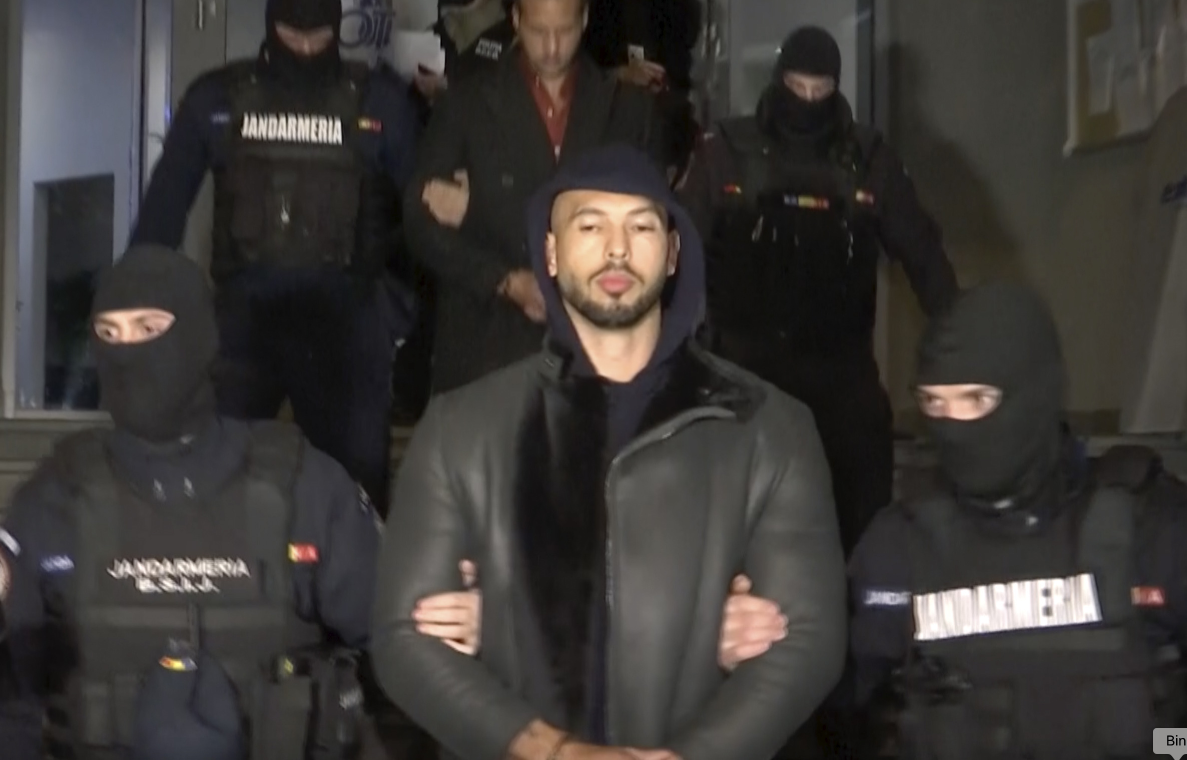 PHOTO: In this grab taken from video released by Observator Antena 1, Social Media personality Andrew Tate is led away by police, in the Ilfov area, north of Bucharest, Romania, Dec. 29, 2022.