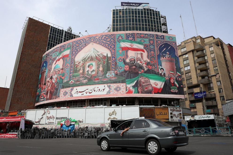 PHOTO: A car drives past a giant billboard in the Valiasr Square in Tehran, Iran, on March 22, 2026.
