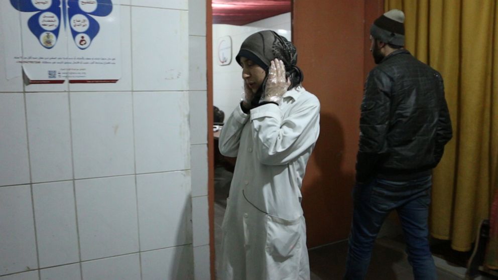 PHOTO: Dr Amani covers her ears during nearby bombings, in Al Ghouta, Syria. 