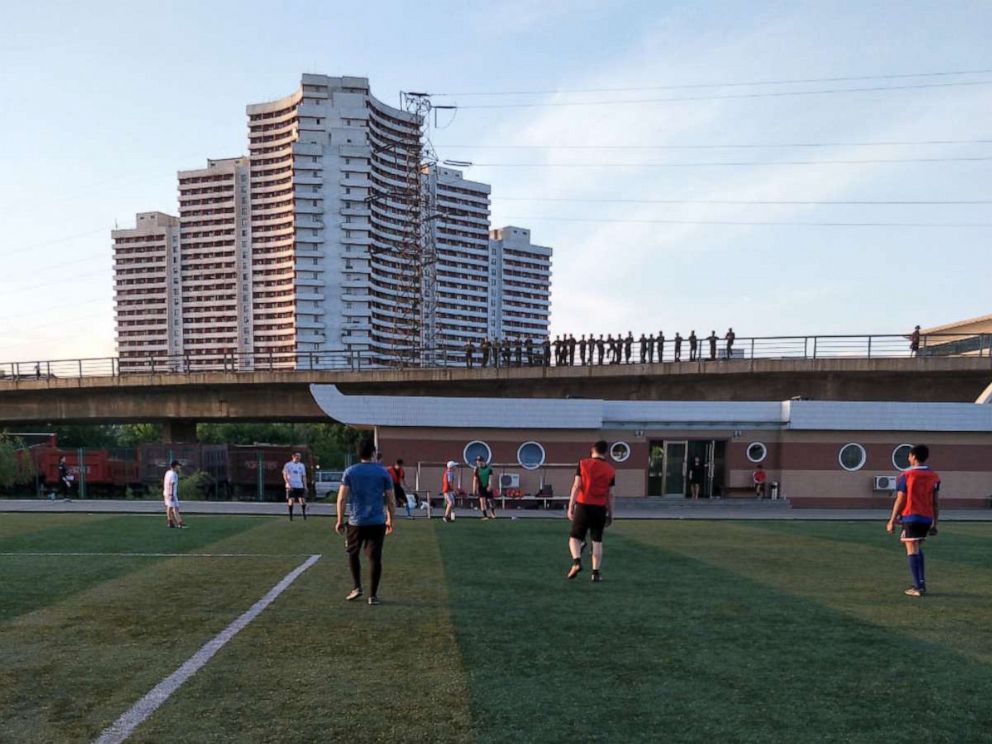 PHOTO: North Korean soldiers watch from an overpass as a group of foreigners play soccer on a field on Tongil Street, Pyongyang, North Korea, May 19, 2018.