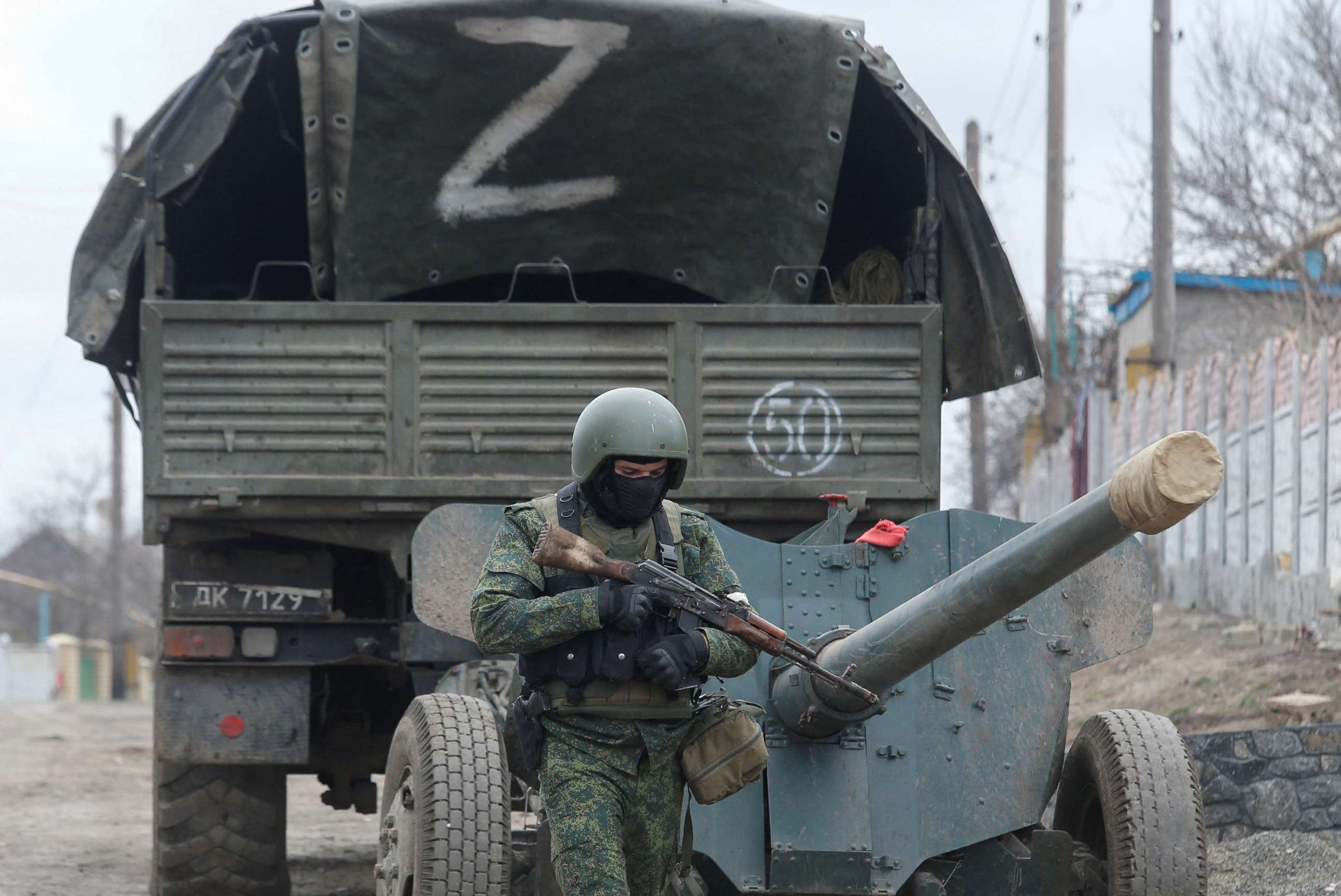 PHOTO: A service member of pro-Russian troops in a uniform without insignia walks past a truck with the letter "Z" painted on its tent top in the separatist-controlled settlement of Buhas (Bugas), Ukraine, March 1, 2022. 