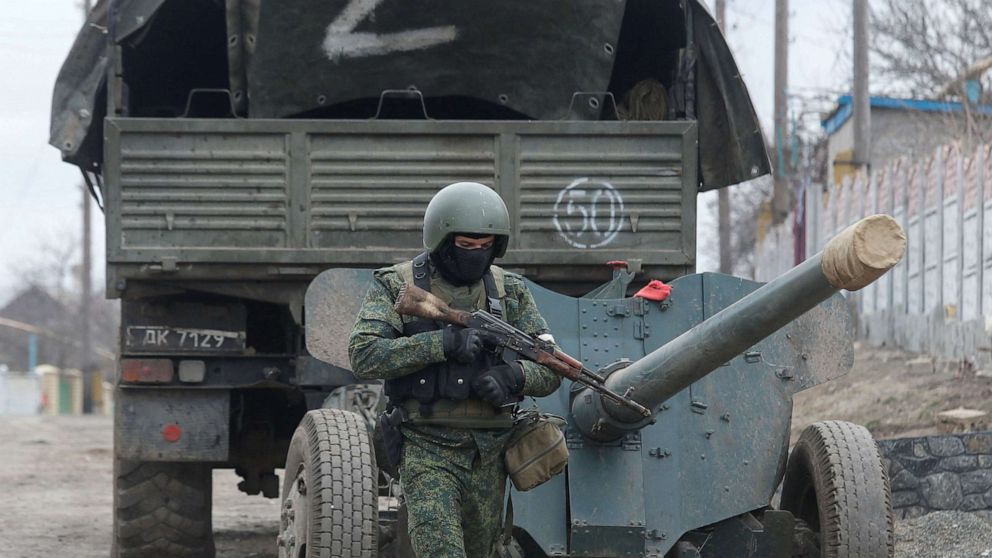 PHOTO: A service member of pro-Russian troops in a uniform without insignia walks past a truck with the letter "Z" painted on its tent top in the separatist-controlled settlement of Buhas (Bugas), Ukraine, March 1, 2022. 