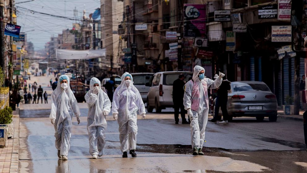 PHOTO: FILE - In this March 24, 2020, file photo, medical workers oversee the disinfection of streets in order to halt the spread of the new coronavirus in Qamishli, Syria. 