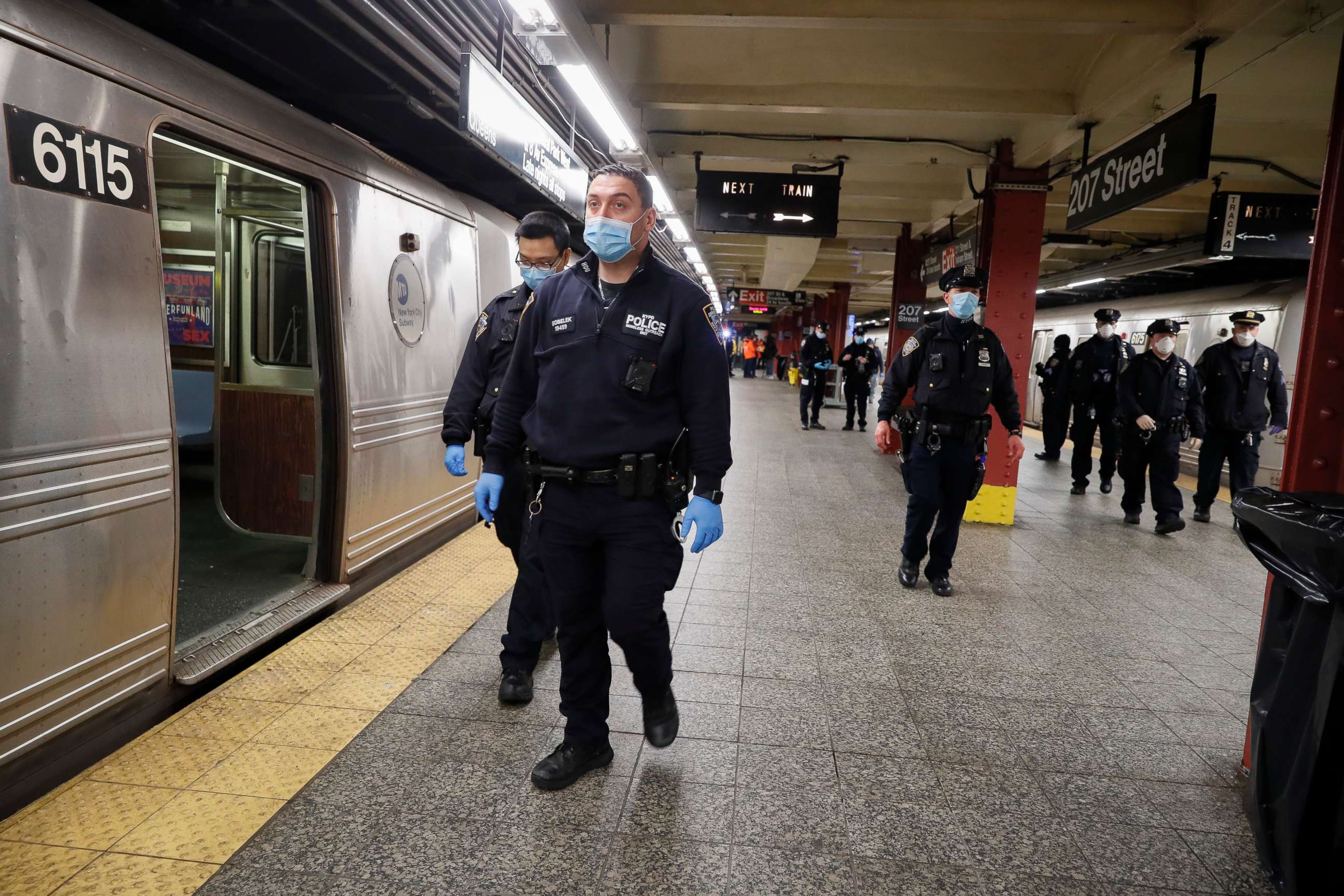 PHOTO: NYPD and MTA officers search cars for sleeping passengers and direct them to the exits at the 207th Street A-train station, April 30, 2020, in the Manhattan borough of New York.