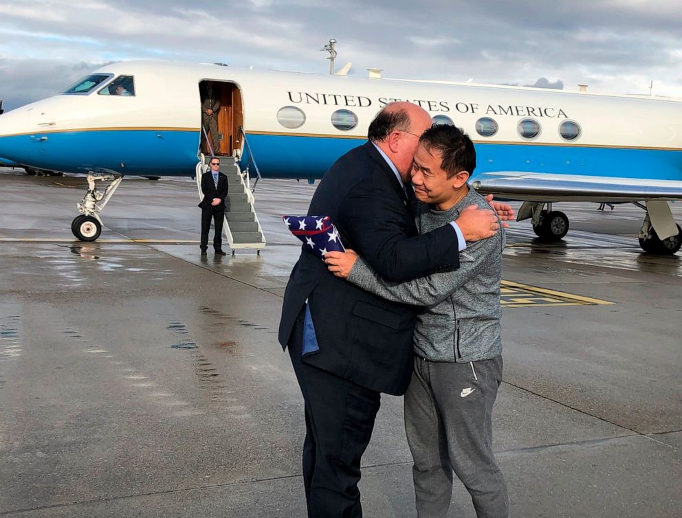 PHOTO: This photo provided by U.S. Embassy Switzerland,  Edward McMullen greets Xiyue Wang in Zurich, Switzerland on Saturday, Dec. 7, 2019.