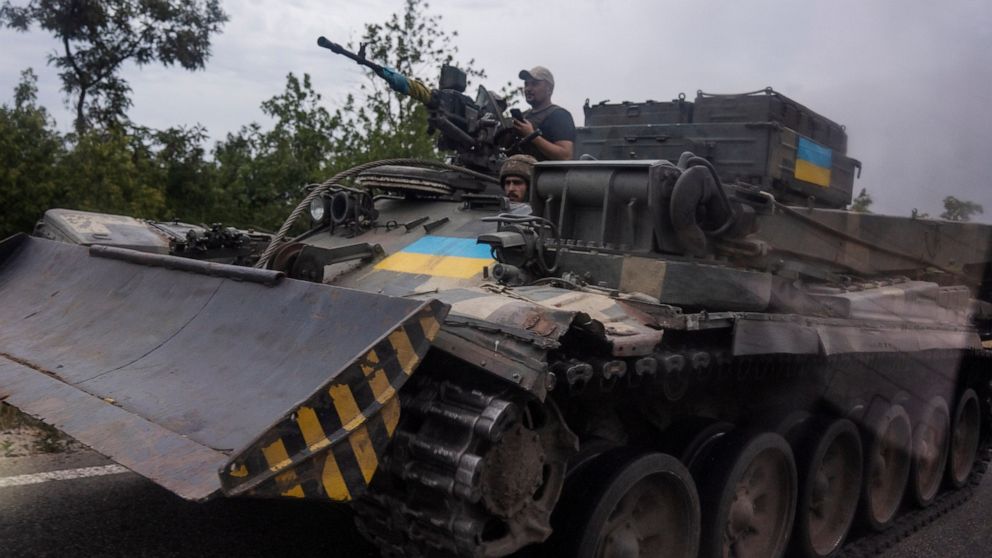 FILE - Ukrainian soldiers ride a tank on a road, in Stupochky, Donetsk region, eastern Ukraine, Sunday, July 10, 2022. Ukrainians living in the path of Russia's invasion in the besieged eastern Donetsk region are bracing themselves for the possibilit