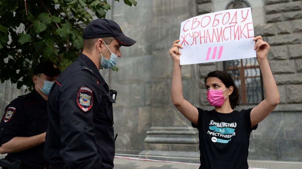 Police detain a journalist with the poster reads "Journalism Freedom", during individual pickets in Moscow, Russia, Saturday, Aug. 21, 2021. Russian police have detained several journalists who protested authorities' decision to label a top independe