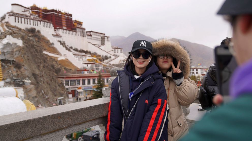 In this Feb. 9, 2019, photo released by Xinhua News Agency, tourists pose for souvenir photos in front of the Potala Palace in Lhasa, southwest China's Tibet Autonomous Region. China is barring foreign travelers from Tibet over a period of several we