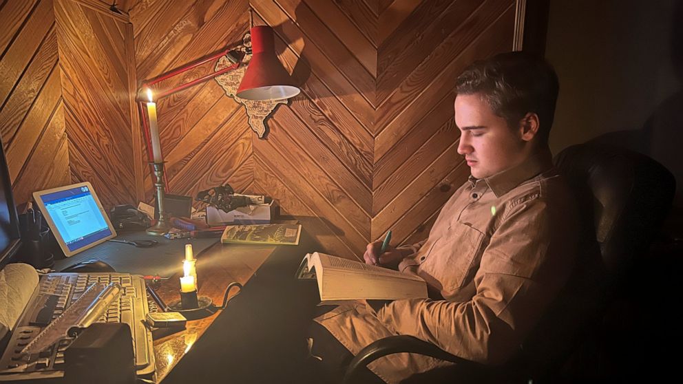 Danylo, 17 has an online biology lesson by candlelight in the village of Start Petrivtsi close to Kyiv, Ukraine, Thursday, Nov. 3, 2022. Rolling blackouts because of Russia's rocket attacks are increasing across Ukraine as the government rushes to st