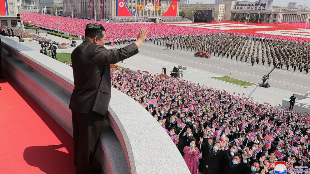 In this photo provided by the North Korean government, North Korean leader Kim Jong Un waves from balcony as he attends a parade to celebrate the 110th birth anniversary of its late founder Kim Il Sung, at the Kim Il Sung Square in Pyongyang, North K