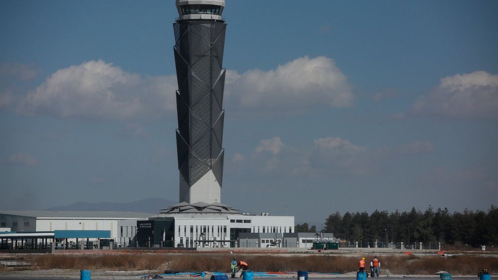 FILE - Backdropped by the air traffic control tower, employees work at the new Felipe Angeles International Airport, on the outskirts of Mexico City, Jan. 31, 2022. Pilots and airlines have expressed concerns in the first week of May 2022, over an in