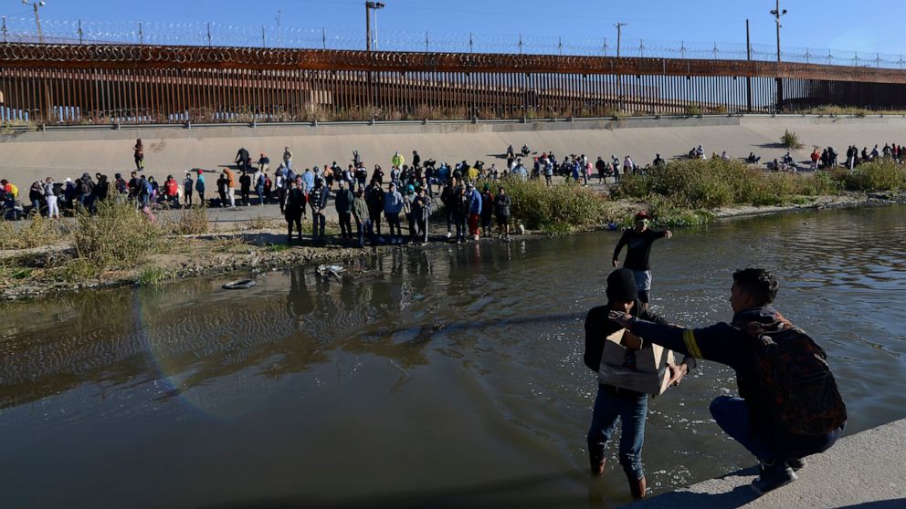 Migrants cross the Mexico-U.S. border to surrender to U.S. Border Patrol agents, in Ciudad Juarez, Mexico, Monday, Dec. 12, 2022. According to the Ciudad Juarez Human Rights Office, hundreds of mostly Central American migrants arrived in buses and cr