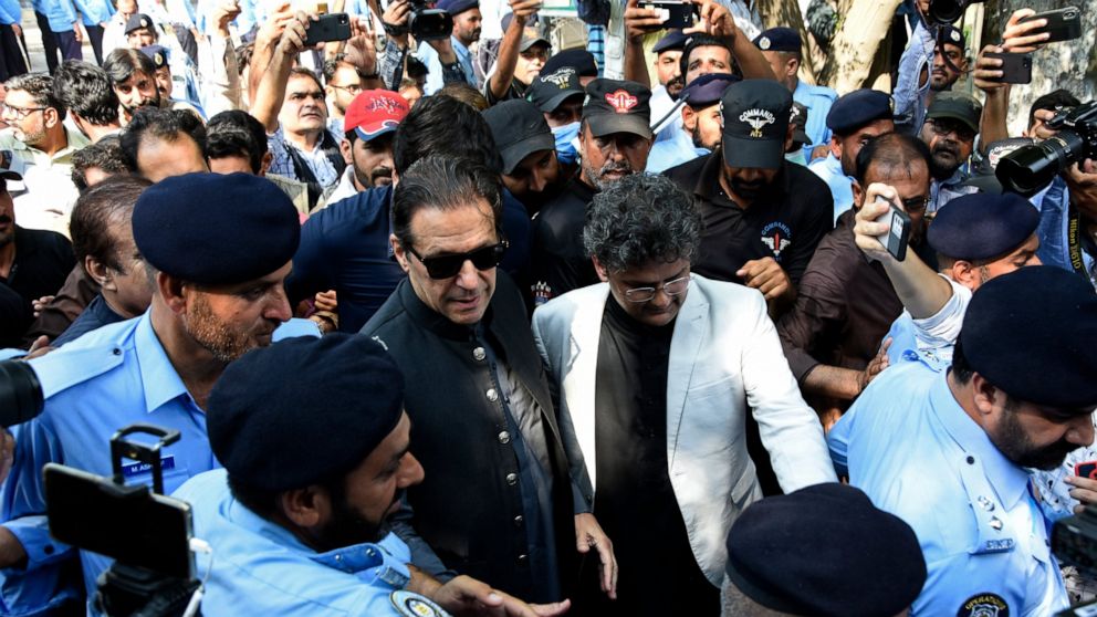 Former Pakistani Prime Minister Imran Khan, center, arrives to the Islamabad High Court surrounded by journalists and security in Islamabad, Pakistan, Thursday, Sept. 8, 2022. Khan appeared in court on Thursday and refused to formally apologize in a 