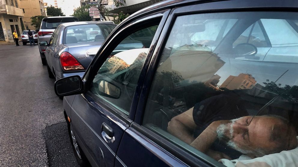 FILE - In this June 12, 2021 file photo, a taxi driver sleeps in the early morning inside his car as he waits in a long queue for gasoline in the Lebanese capital, Beirut. Lebanon is struggling amid a 20-month-old economic and financial crisis that h