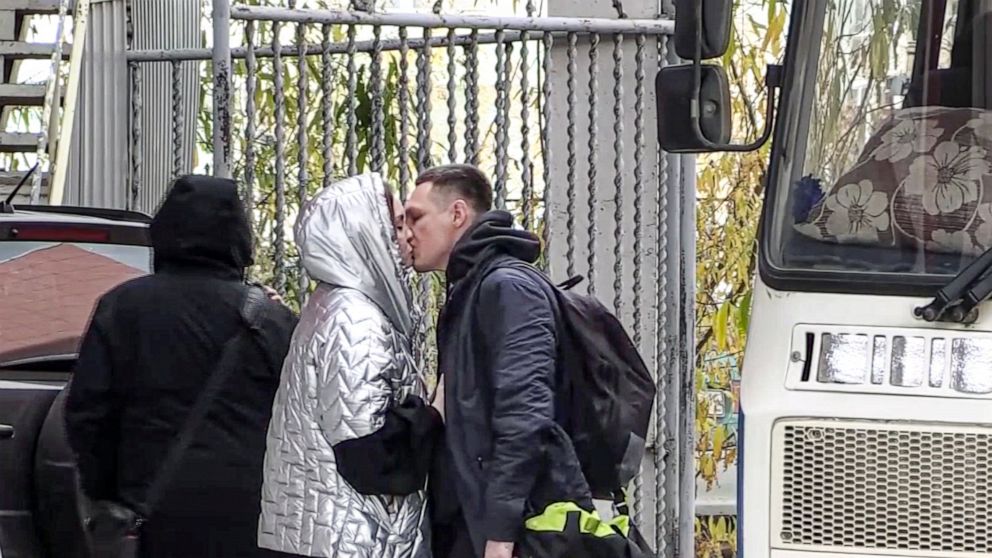 In this image taken from video, a Russian draftee kisses his partner before boarding a bus to be sent to the military units of the Eastern Military District, in Yakutsk, Russia, Friday, Sept. 23, 2022. Mobilization is underway in Russia's Far Eastern