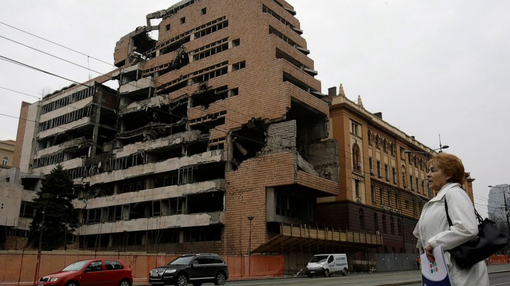 FILE - A woman walks in front of the destroyed former Serbian army headquarters in Belgrade, Serbia, on March 24, 2010. Well before Russian tanks and troops rolled into Ukraine, Vladimir Putin was using the bloody breakup of Yugoslavia in the 1990s t