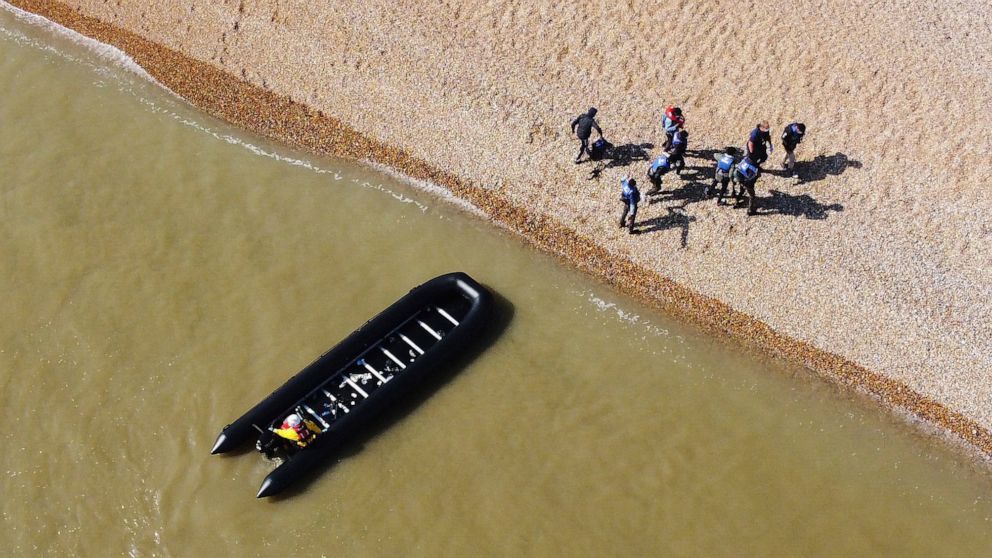A group of people thought to be migrants are escorted to shore in Kingsdown, after being intercepted by an RNLI crew following a small boat incident in the Channel, in Kent, England, Tuesday, Sept. 7, 2021. (Gareth Fuller/PA via AP)