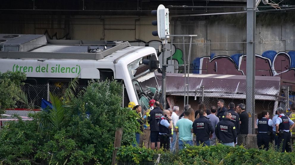 Police and rescue workers stand by the wreckage after a train crash in Sant Boi near Barcelona, Spain, Monday, May 16, 2022. A goods train smashed into a rush-hour passenger train in Catalonia, killing an engineer and injuring 85 people as it came in