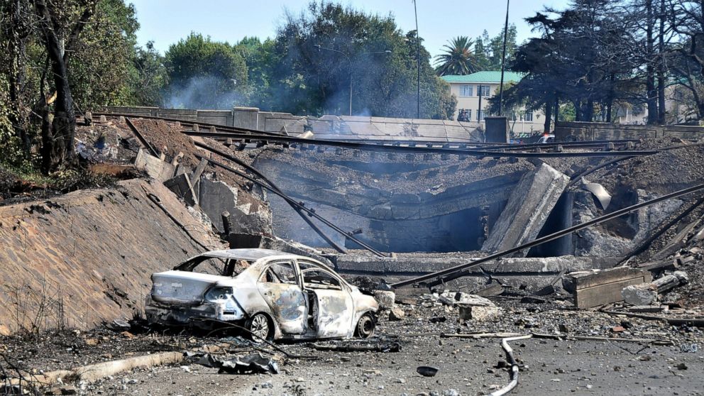 A burned out vehicle marks the spot where a gas tanker exploded under a bridge in Boksburg, east of Johannesburg, Saturday, Dec. 24, 2022. A truck carrying liquified petroleum gas has exploded in the South African town of Boksburg, killing at least 8