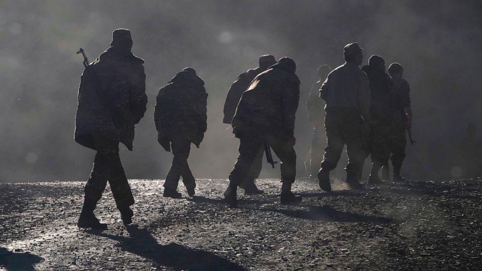 FILE - Ethnic Armenian soldiers walk along the road near the border between Nagorno-Karabakh and Armenia, Nov. 8, 2020. Judges at the United Nations’ top court ordered Azerbaijan on Tuesday Dec. 7, 2021, to protect all the prisoners it captured durin