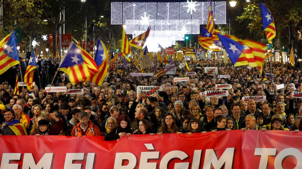 Protesters hold a banner that reads in Catalan ''Knock down the regime'' during a rally in Barcelona, Spain, Friday, Dec. 21, 2018. Thousands of pro-independence protesters angry about Spain's Cabinet holding a meeting in Catalonia blocked roads acro