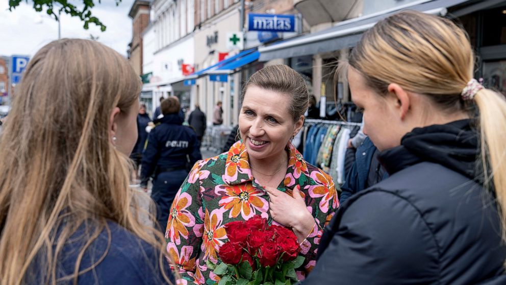 FILE - Denmark's Prime Minister Mette Frederiksen, centre, speaks to people while on an election campaign, in Holbaek, Denmark, Saturday, May 28, 2022. Voters on Wednesday will decide whether to abandon their country's 30-year-old opt-out from the bl
