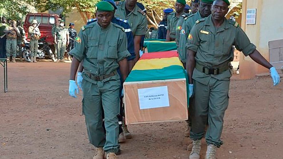 In this photo made available on the Mali Army twitter feed, showing coffins being honoured at a funeral ceremony in Gao, Mali, Wednesday Nov. 20, 2019. The Mali Defense Ministry held a funeral for the 30 soldiers killed in a Monday attack on an army 