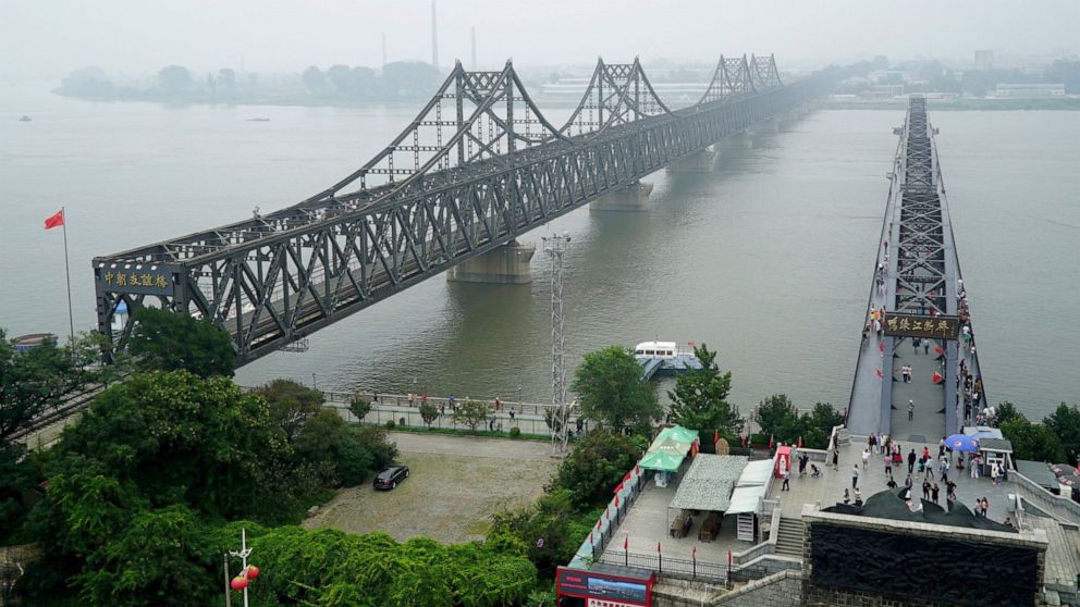 FILE -Visitors walk across the Yalu River Broken Bridge, right, next to the Friendship Bridge connecting China and North Korea in Dandong in northeastern China's Liaoning province, Sept. 9, 2017. North Korea and China resumed freight train service Mo
