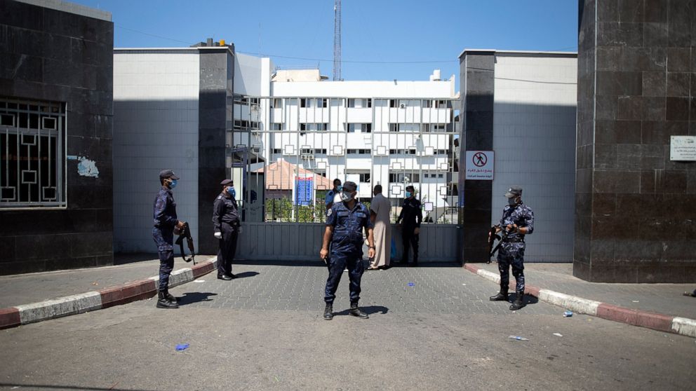 Hamas police officers guard the entrance of the Shifa Hospital after coronavirus cases were discovered in the hospital, in Gaza City, Wednesday, Aug. 26, 2020. Gaza health officials have reported the first death from COVID-19 since authorities detect