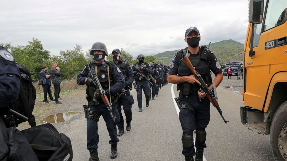 Kosovo police officers walk to replace their colleagues near the northern Kosovo border crossing of Jarinje on Tuesday, Sept. 21, 2021. Tensions soared Monday when Kosovo special police with armored vehicles were sent to the border to impose a rule o