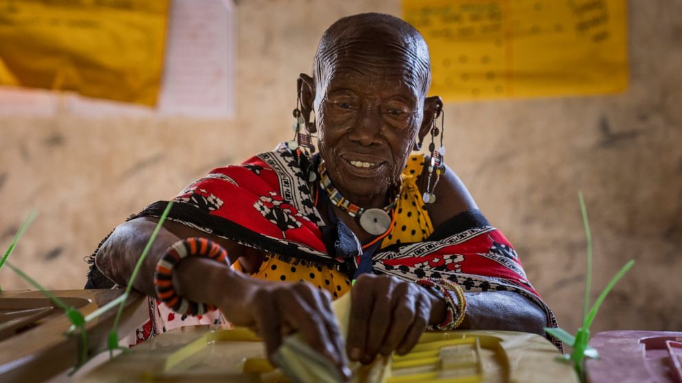 A Maasai woman casts her vote at a polling station in Esonorua Primary School, in Kajiado County, Kenya Tuesday, Aug. 9, 2022. Polls opened Tuesday in Kenya's unusual presidential election, where a longtime opposition leader who is backed by the outg
