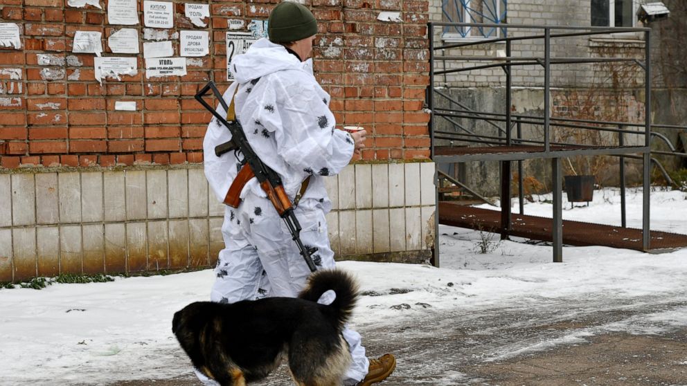 A Ukrainian serviceman patrols a street near frontline with with Russia-backed separatists in Verkhnotoretske village in Yasynuvata district, Donetsk region, eastern Ukraine, Saturday, Jan. 22, 2022. Russia on Thursday announced sweeping naval drills