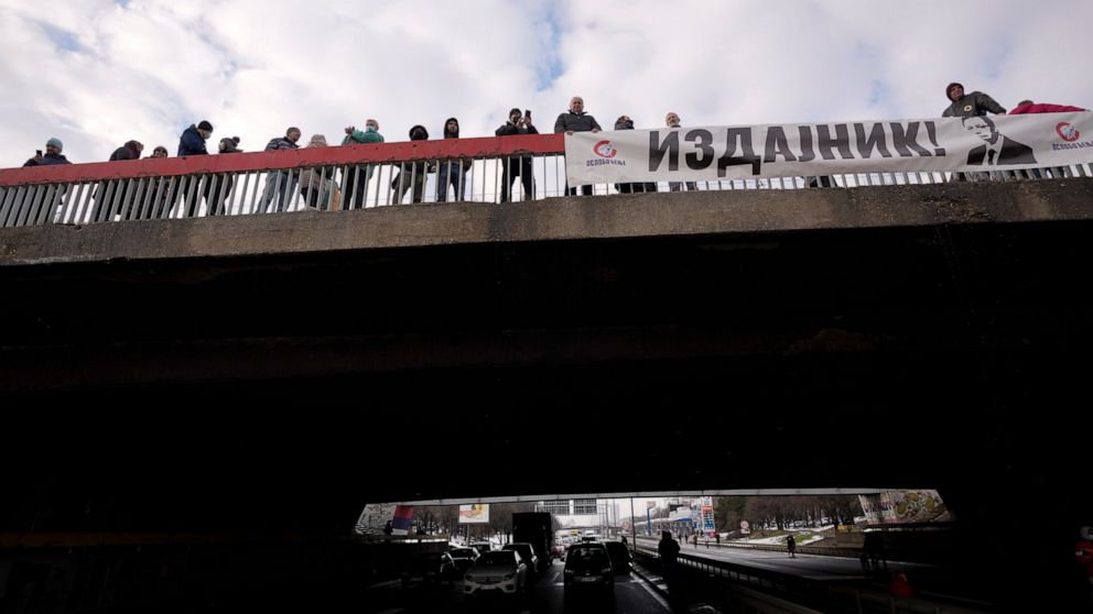 Environmental demonstrators hold banner showing an image of Serbian President Aleksandar Vucic, reading: "A traitor!" as they block a highway during a protest in Belgrade, Serbia, Saturday, Jan. 15, 2022. Hundreds of environmental protesters demandin