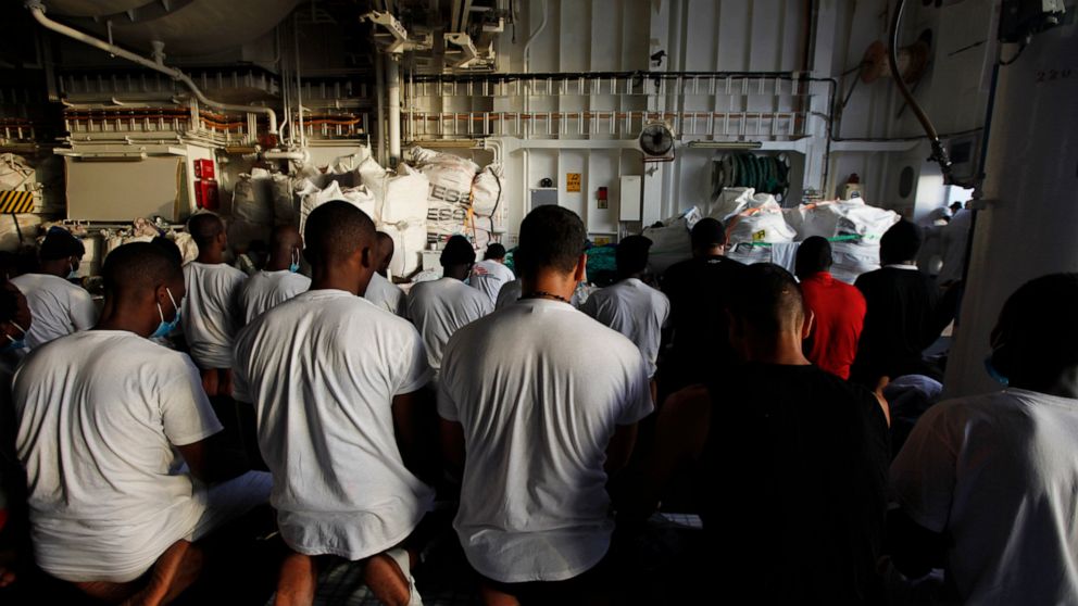 Migrants pray on the deck of the Geo Barents, a rescue vessel operated by MSF (Doctors Without Borders) off Libya, in the central Mediterranean route, Wednesday, Sept. 22, 2021. (AP Photo/Ahmed Hatem)