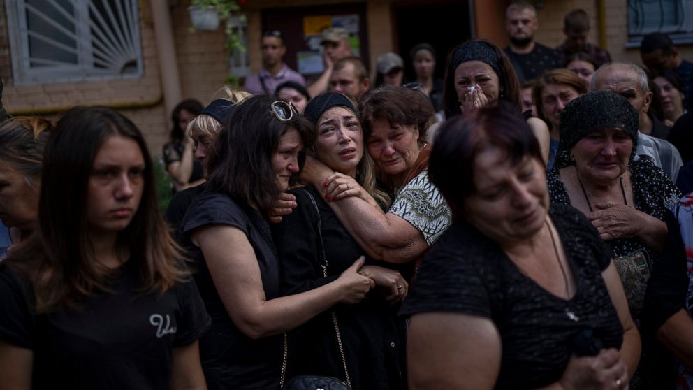 Anastasia Ohrimenko, 26, is comforted by relatives and friends as she cries next to a coffin with the body of her husband Yury Styglyuk, a Ukrainian serviceman who died in combat on August 24 in Maryinka, Donetsk, during his funeral in Bucha, Ukraine