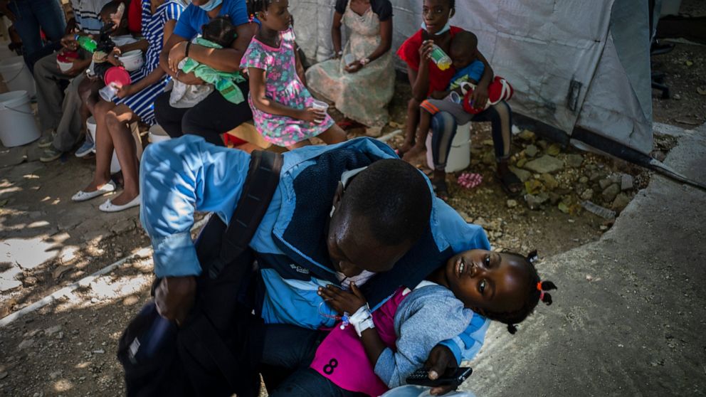 A girl suffering from cholera symptoms is helped by her father upon arrival at a clinic run by Doctors Without Borders in Port-au-Prince, Haiti, Thursday, Oct. 27, 2022. For the first time in three years, people in Haiti have been dying of cholera, r
