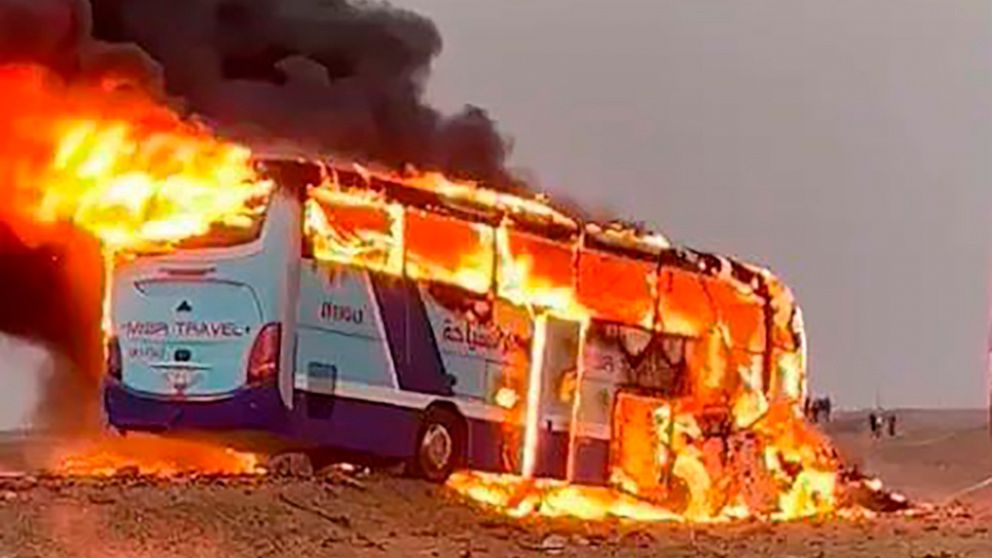 A tourist bus burns after it collided with a truck on a highway 55 kilometers (34 miles) south of Aswan, southern Egypt, Wednesday, April 13, 2022. At least 10 people including four French and a Belgian, were killed, authorities said. (AP Photo)