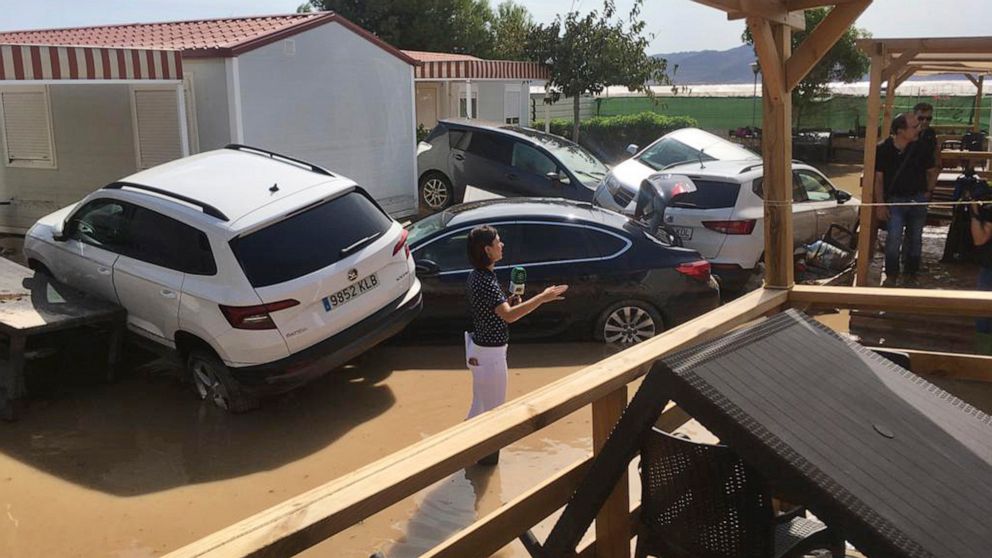 A TV reporter reports from a flooded campsite in the Cabo de Gata area, near Ruescas, Almeria in south-eastern Spain, Friday Sept. 13, 2019. Spanish authorities say that heavy storms in the southeast have claimed another victim, bringing the death to
