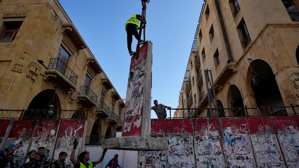 A team of engineers removes a concrete wall from a road that leads to the parliament building in Beirut, Lebanon, Monday, May 23, 2022. Lebanese authorities began removing giant cement barriers surrounding the parliament building in Beirut Monday, a 