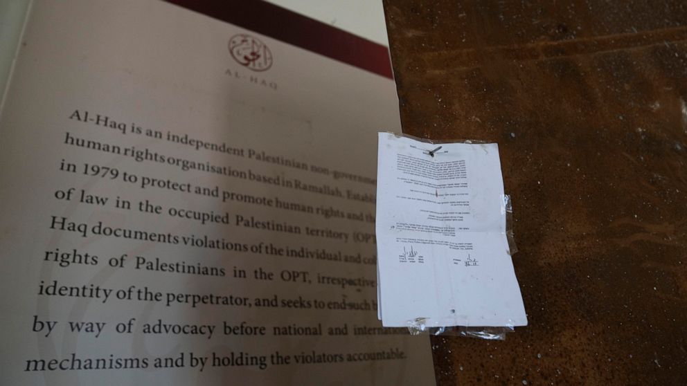An Israeli army closure order hangs on the door of the sealed office of the al-Haq human rights organization that was raided by Israel forces, in the West Bank city of Ramallah, Thursday, Aug. 18, 2022. Israel raided the offices of several Palestinia