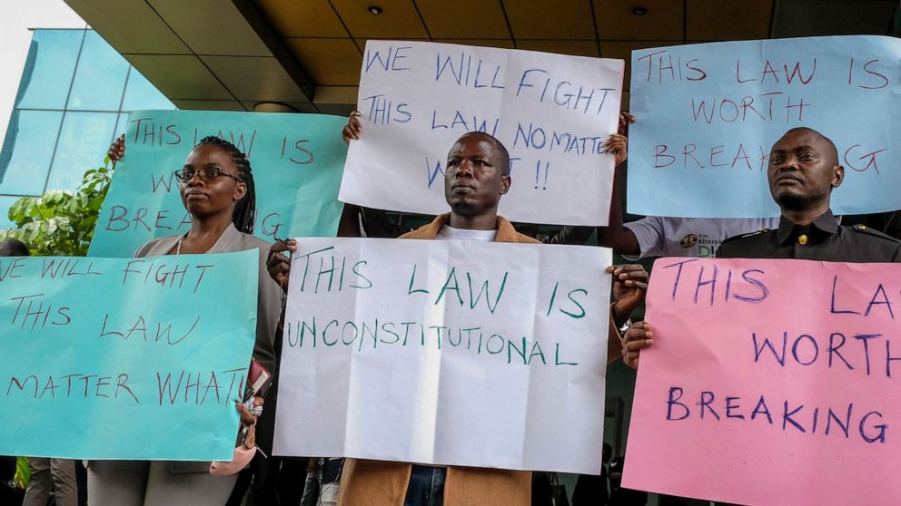 Digital activists hold placards as they demonstrate after submitting a legal petition against controversial new legislation criminalizing some internet activity, at the constitutional court in Kampala, Uganda, Monday, Oct. 17, 2022. The petition to t