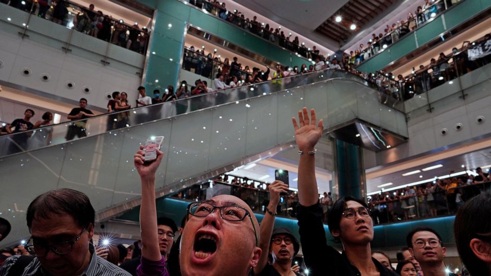 Local residents sing a theme song written by protesters "Glory be to thee" at a shopping mall in Hong Kong Wednesday, Sept. 11, 2019. Hundreds of Hong Kong citizens gathered at several malls late Wednesday, chanting slogans and belting out a new prot
