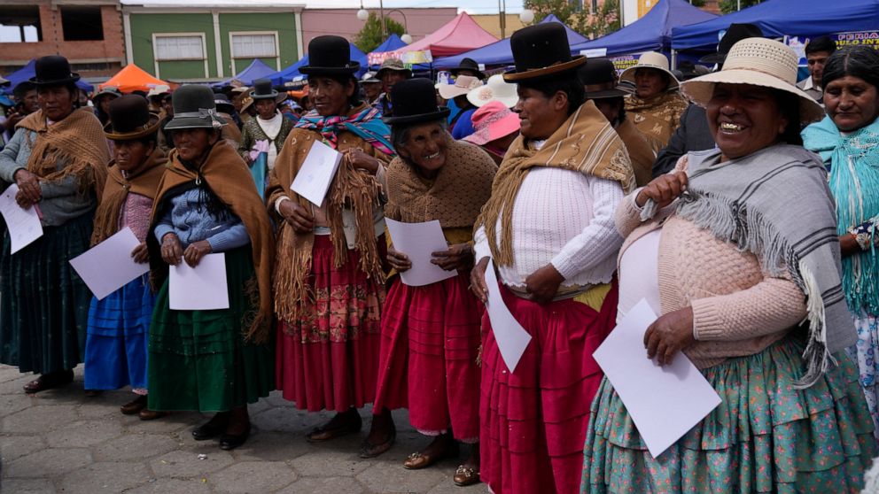 Aymara Indigenous women smile after receiving their certificate during an adult literacy graduation ceremony in Pucarani, Bolivia, Sunday, Dec. 4, 2022. (AP Photo/Juan Karita)