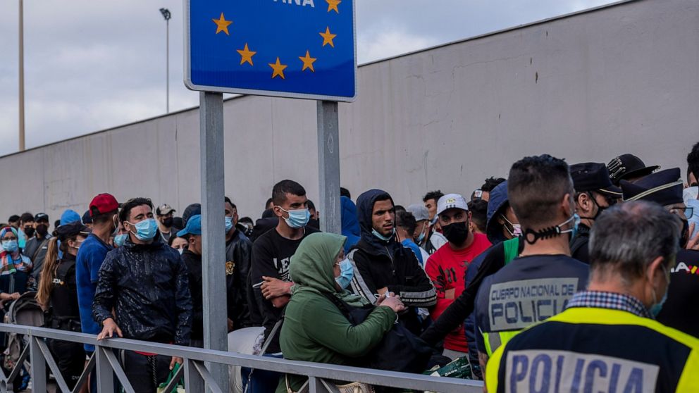 FILE - Moroccans, including many who have been in the Spanish enclave of Ceuta since before the border crisis, wait at the border to return voluntarily to their home country, Thursday, May 20, 2021. The land borders between Spain and Morocco at Ceuta
