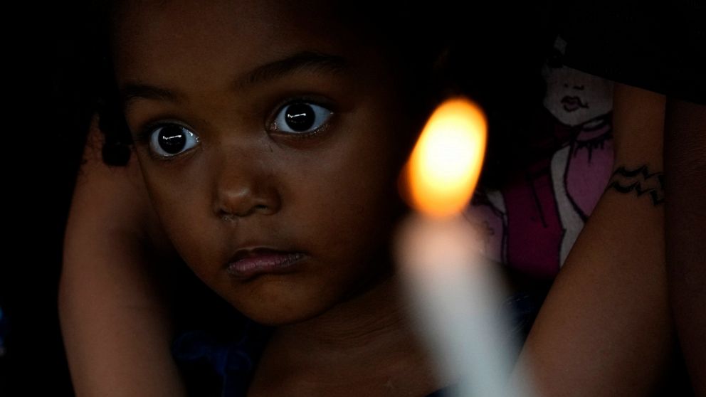 A girl stands in her home in Quilombo Mesquita, a community of descendants from slaves, during its traditional cultural-religious festival "Folia do Divino Espirito Santo", in Cidade Ocidental, 50 km from Brasilia, Brazil, Thursday, May 12, 2022. The