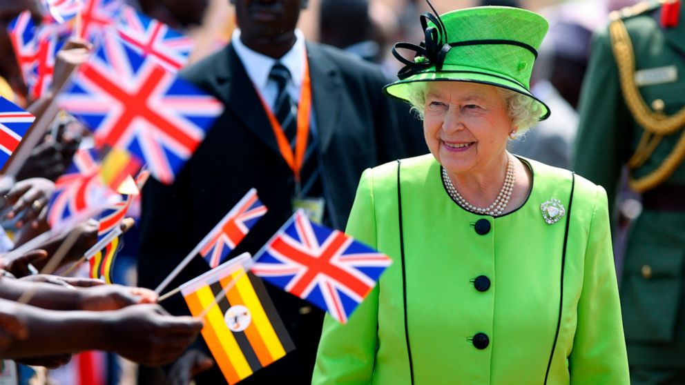 FILE - Britain's Queen Elizabeth II walks past staff and patients at the Mildmay HIV Centre in Kampala, Uganda, on the first day of her state visit to Uganda, Nov. 22, 2007. Queen Elizabeth II, Britain’s longest-reigning monarch and a rock of stabili