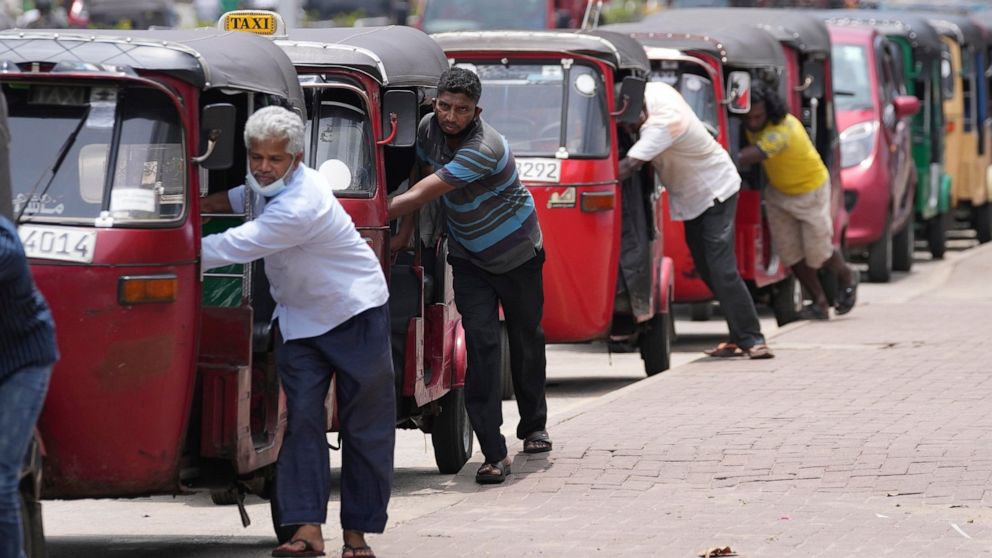 FILE- Sri Lankan auto rickshaw drivers queue up to buy petrol near a fuel station in Colombo, Sri Lanka, Wednesday, April 13, 2022. China says its initiative to build ports and other infrastructure paid for with Chinese loans across Asia and Africa w