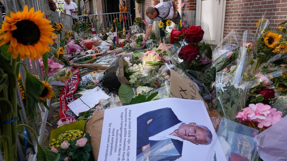 HIs picture and flowers mark the spot where journalist Peter R. de Vries was shot in Amsterdam, Netherlands, Thursday, July 8, 2021. Peter R. de Vries, who is widely lauded for fearless reporting on the Dutch underworld, was shot Tuesday July 6, 2021