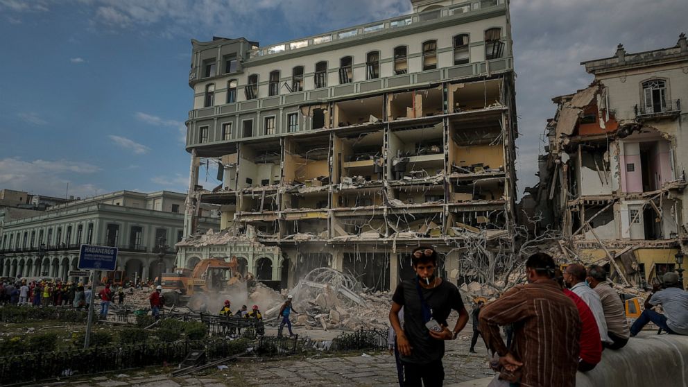 People watch the rescue effort at the site of a deadly explosion that destroyed the five-star Hotel Saratoga, in Havana, Cuba, Friday, May 6, 2022. A powerful explosion apparently caused by a natural gas leak killed at least 18 people, including a pr