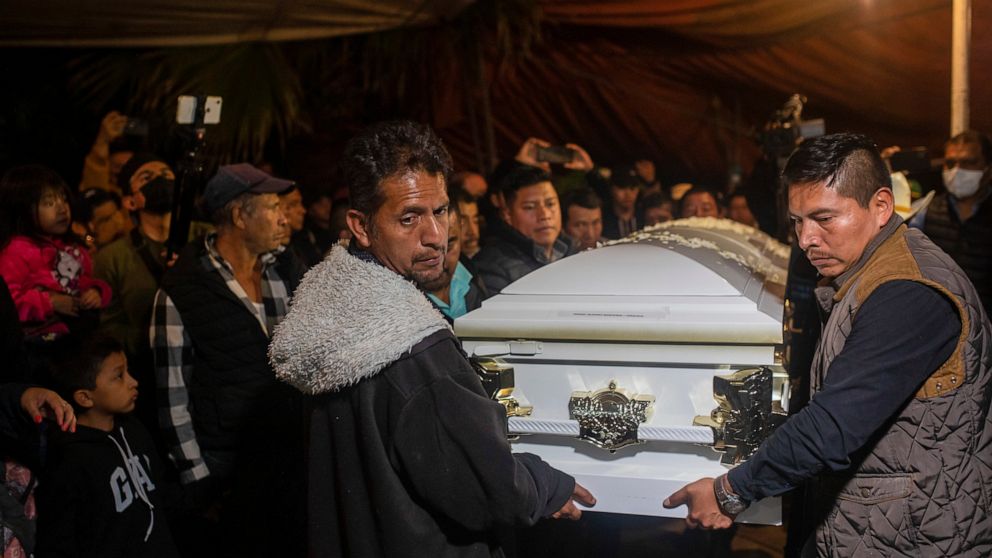Relatives carry the coffin with the remains of Jair Valencia, Misael Olivares, and Yovani Valencia at their family house in San Marcos Atexquilapan, Veracruz state, Mexico, Wednesday, July 13, 2022. The three were among a group of migrants who died o